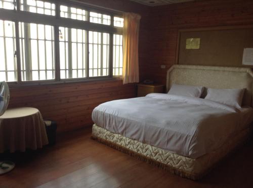 a bedroom with a large bed and two windows at Bunbury Fruit Ranch B&B in Renai