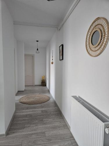 a hallway with white walls and a mirror on the wall at Tei Residence in Piatra Neamţ
