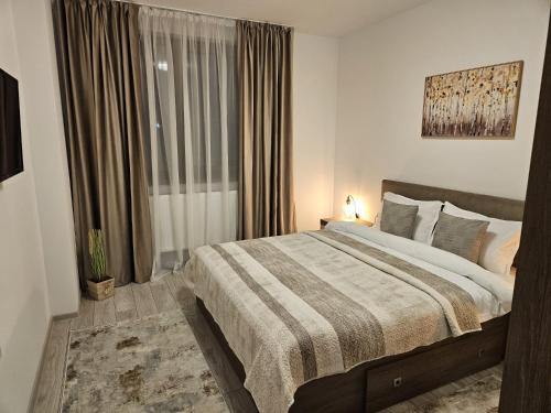 a bedroom with a large bed and a window at Tei Residence in Piatra Neamţ