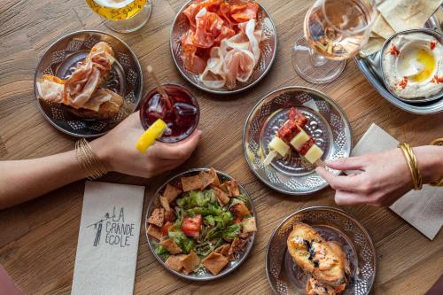 a wooden table with plates of food on it at Hôtel Lilybloom in Le Havre