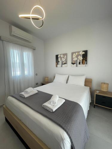 a bedroom with a large bed with two towels on it at Villa Rodelia 1 in Roda