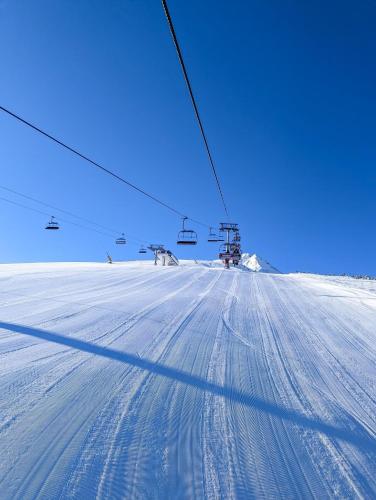 a shadow of a person riding a ski lift in the snow at Spacious penthouse chalet apartment in Pirin Golf and Country Club in Razlog