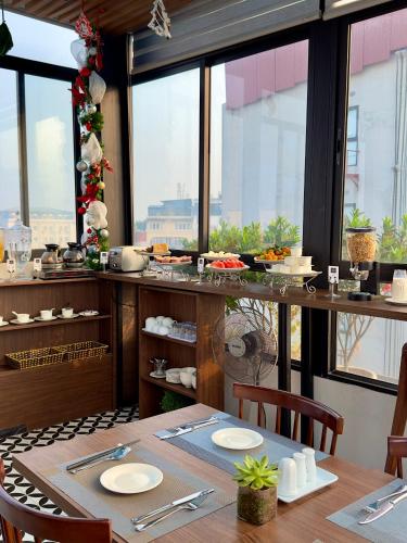 a dining room with a table and some windows at The Cosy Inn Hanoi in Hanoi