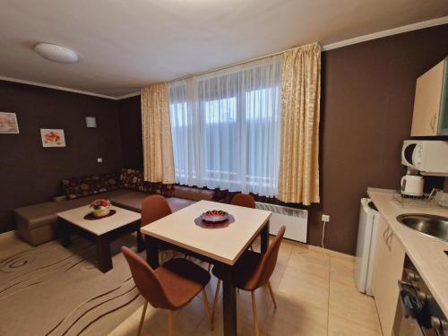 cocina y sala de estar con mesa y sillas en апартаменти Уют Гранд Манастира, en Pamporovo