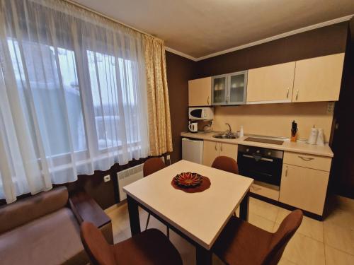 una pequeña cocina con mesa y sillas en una habitación en апартаменти Уют Гранд Манастира, en Pamporovo