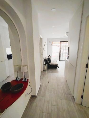 a living room with a red table and a couch at El Diamantino 202 WiFi Pool in Los Cristianos