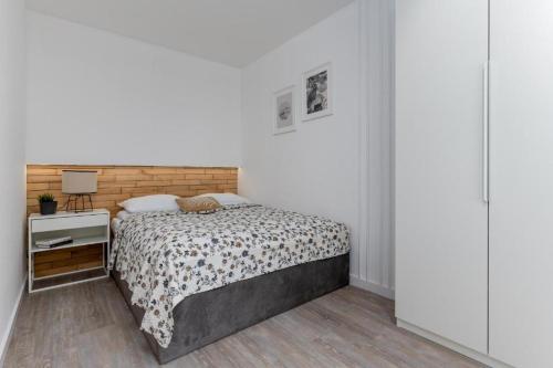 una camera bianca con letto e comodino di Bielsko Bliss Suites a Bielsko-Biała