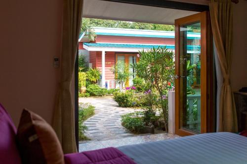 a bedroom with a door open to a walkway at Thai Smile Bungalows in Ko Lanta
