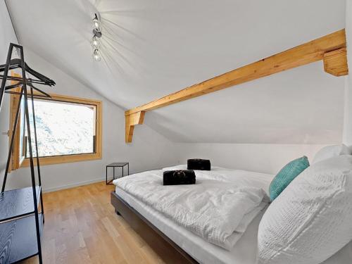 1 dormitorio con cama blanca y ventana en The Laughing Cow - 10 mns from Sion and ski, en Ayent