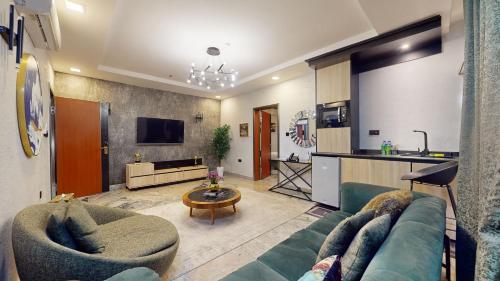 a living room with a couch and a kitchen at YANNA APARTMENT BY KHALIQUES in Abuja