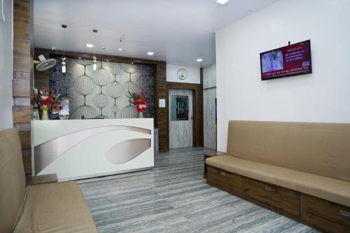 Sonar Bangla Guest House في كولْكاتا: غرفة انتظار مع أريكة وتلفزيون
