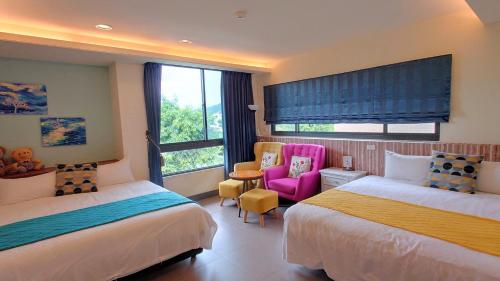 Jiji的住宿－倍詩泰民宿 ，酒店客房,设有两张床和一张粉红色的椅子