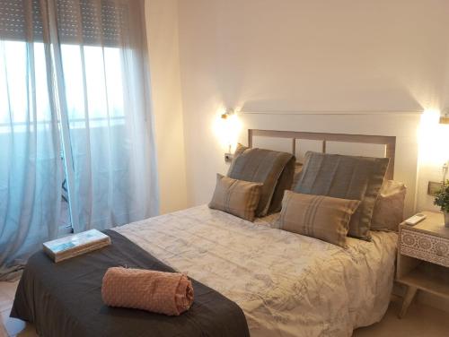 ein Schlafzimmer mit einem Bett und einem großen Fenster in der Unterkunft Love House Andalucia in La Envia