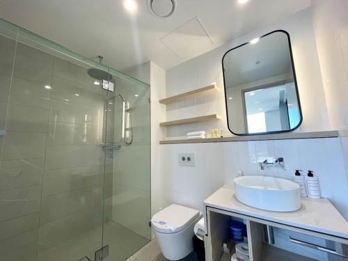 een badkamer met een wastafel en een douche met een spiegel bij In the heart of Surfers Paradise oceanview cozy 1B Apt 34F in Gold Coast
