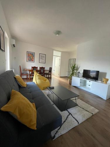 un soggiorno con divano nero e tavolo di Apartman Dolly Bell a Kotor-Varoš