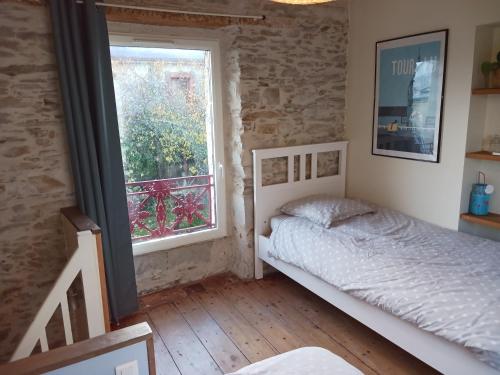 1 dormitorio con cama y ventana en Le pigeonnier de la plume en Nantes