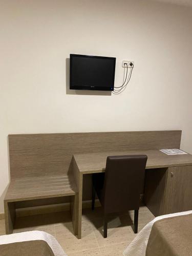 a wooden desk with a television on the wall at Ca La Maria in Tordera