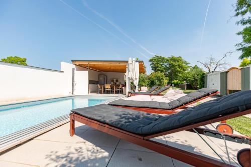 two beds sitting on a patio next to a swimming pool at Uiferhäuser in Illmitz