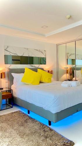 a bedroom with a large bed with yellow pillows at Sukhumvit13 Luxury suite in Bangkok