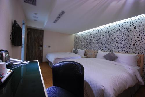 a hotel room with two beds and a glass table at 欣欣旅店 in Taipei