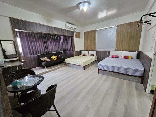 a living room with two beds and a couch at Peace 28 B&B in Jincheng