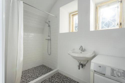 a white bathroom with a sink and a shower at Chalupa Kolowrat in Horka