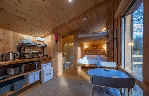 a log cabin kitchen with a bed and a desk at Rivendell Bothan in Spean Bridge