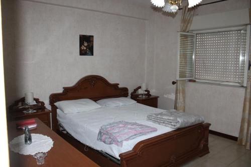 a bedroom with a bed and a table and a window at Grazioso appartamento vicino al mare in Giardini Naxos