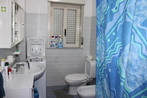 y baño con aseo y lavamanos. en Grazioso appartamento vicino al mare, en Giardini Naxos