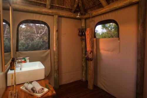 a bathroom with a sink and two windows at Elephants Safari Lodge - Bellevue Forest Reserve in Paterson