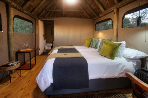 Elephants Safari Lodge - Bellevue Forest Reserve في باترسون: سرير كبير في غرفة بها نوافذ