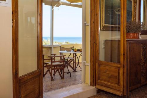 a door leading to a dining room with a view of the ocean at Palaiopolis house in Avlemonas