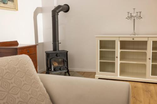 a fireplace in a living room with a couch and a stove at Chalupa Kolowrat in Horka