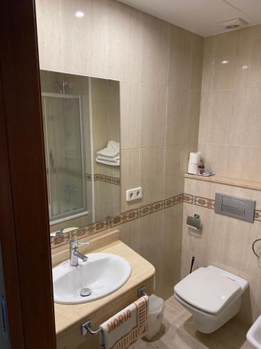 a bathroom with a sink and a toilet and a mirror at Ca La Maria in Tordera