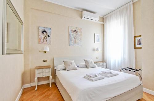 a bedroom with a white bed and a window at Roberta Apartment Fontana di Trevi in Rome