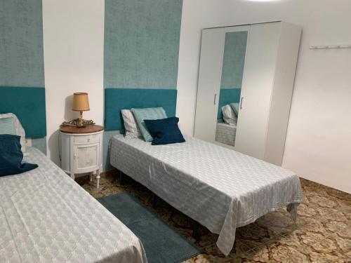 a bedroom with two beds and a mirror at Sagunto 2 in Sagunto