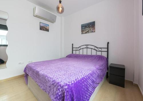 - une chambre avec un lit doté d'un couvre-lit violet dans l'établissement Solymar, à Chipiona