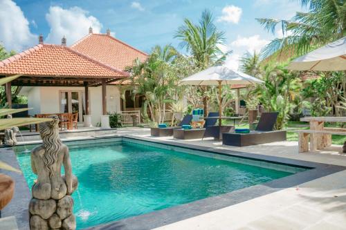 a pool with a statue in front of a house at Bingin Garden Uluwatu in Uluwatu