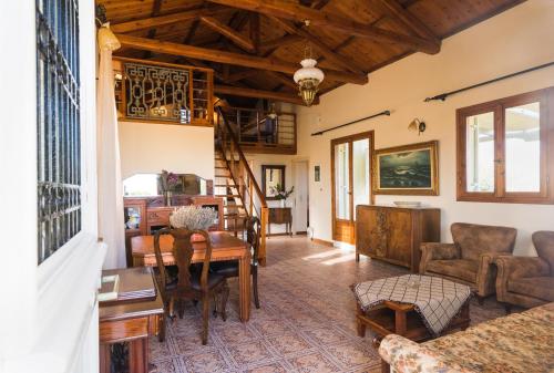 a living room with a table and chairs and a staircase at Palaiopolis house in Avlemonas