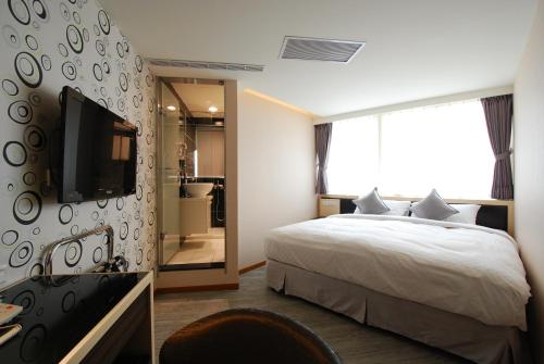 a bedroom with a bed and a tv and a mirror at 欣欣旅店 in Taipei