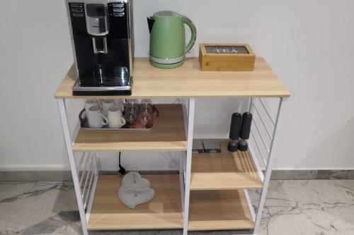 a small shelf with a coffee maker and a coffee pot on it at A O G prestige Relax Max SPA SAUNA in Algolsheim