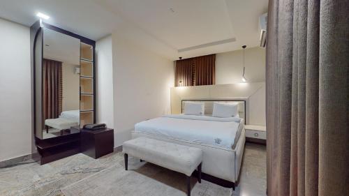 a hotel room with a bed and a mirror at YANNA APARTMENT BY KHALIQUES in Abuja