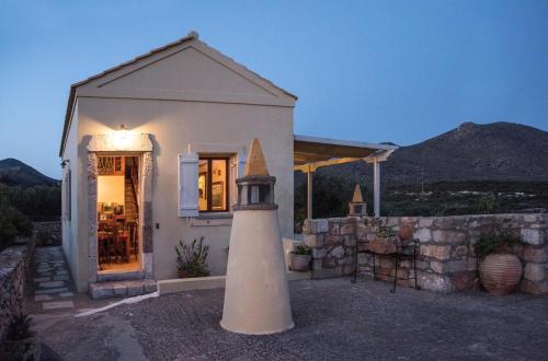 a small white house with a lighthouse in front of it at Palaiopolis house in Avlemonas