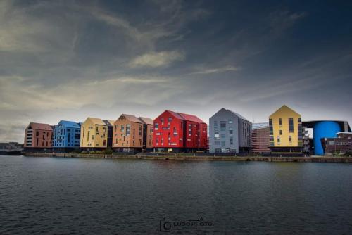 a row of colorful buildings next to a body of water at Maison de Ville restylée avec jardin, proche gare in Dunkerque