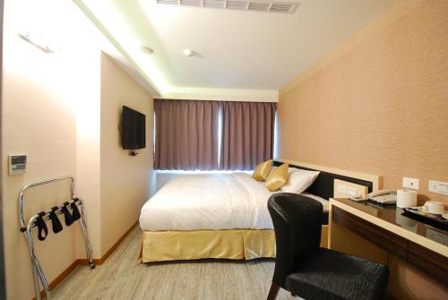 a hotel room with a bed and a desk at 欣欣旅店 in Taipei