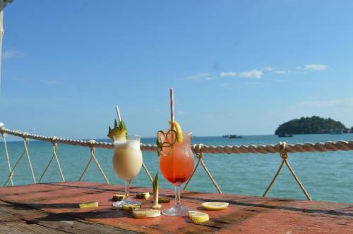 dois cocktails sentados numa mesa perto da água em Salacia's Suite em Koh Rong Island
