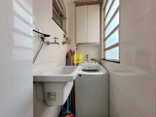 a small white bathroom with a sink and a window at Europe Garden Apartment, 3 quartos in Juiz de Fora