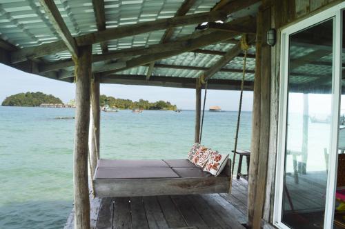um baloiço de varanda numa casa sobre a água em Salacia's Suite em Koh Rong Island