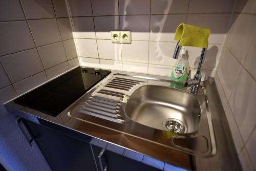 um lavatório de aço inoxidável numa pequena casa de banho em Ferienwohnung Laubegast em Dresden