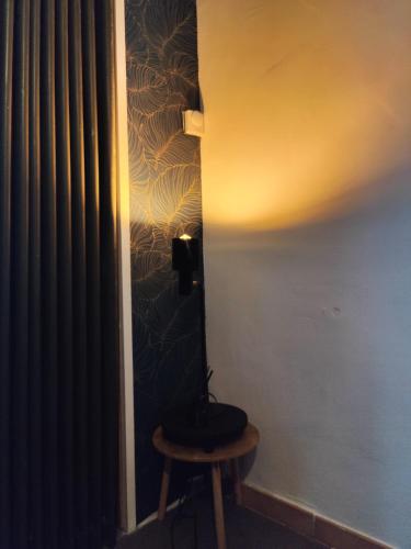 a room with a stool and a wall with a lamp at Find yourself apartment Dunkerque in Coudekerque-Branche